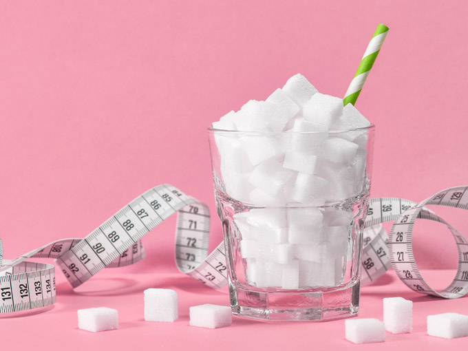 Glas mit Zuckerwürfeln – beim Diabetes Typ 2 sollte die Ernährung zuckerarm sein