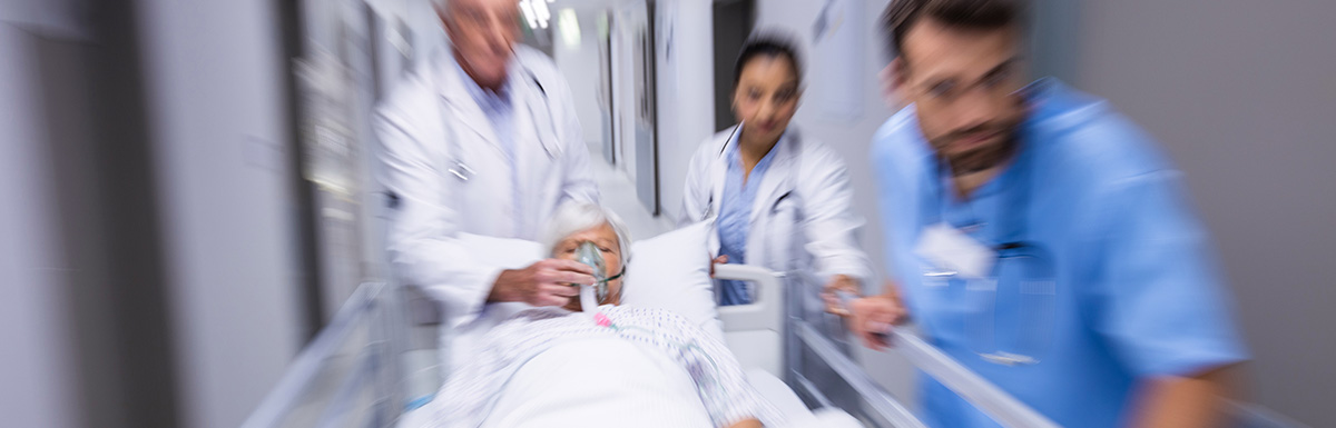 Medizinisches Personal im Krankenhaus schiebt einen Patienten auf einem Bett
