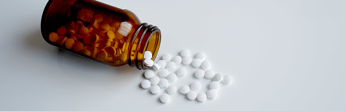 Gekipptes Glas mit weißen Tabletten - Medikamente mit Cortison können Diabetes begünstigen.