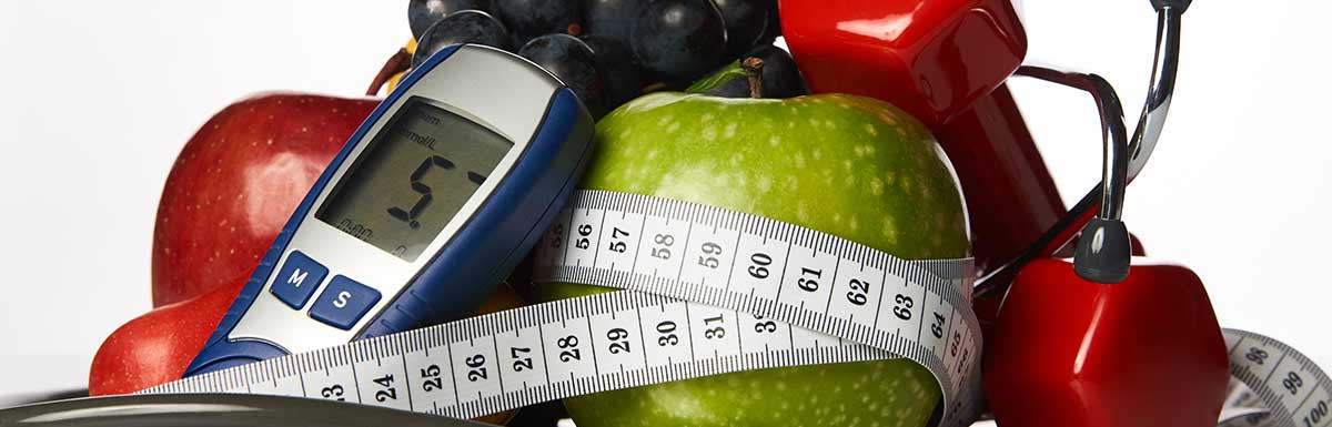 Maßband, Äpfel und ein Blutzuckermessgerät vor weißem Hintergrund: Bei Diabetes Sport zu treiben ist sehr empfehlenswert.
