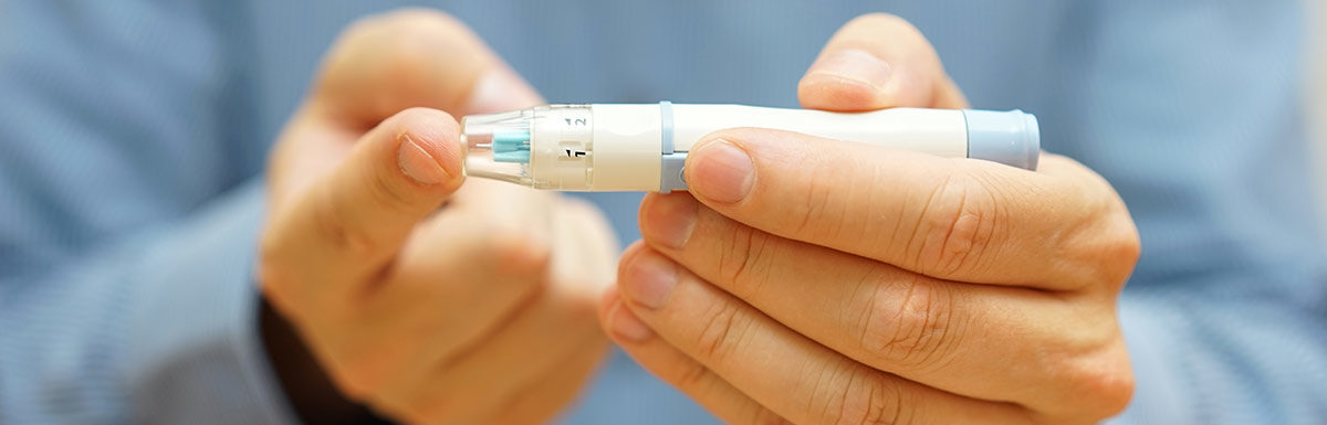 Ein Mann sticht sich in die Fingerspitze, um seinen Blutzucker zu messen und seinen Diabetes-Korrekturfaktor zu ermitteln.