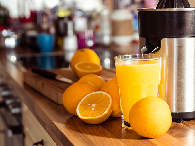 Mehrere Orangen liegen neben einem Glas frisch gepresstem Saft - bei der Therapie einer Unterzuckerung kann Fruchtzucker hilfreich sein.